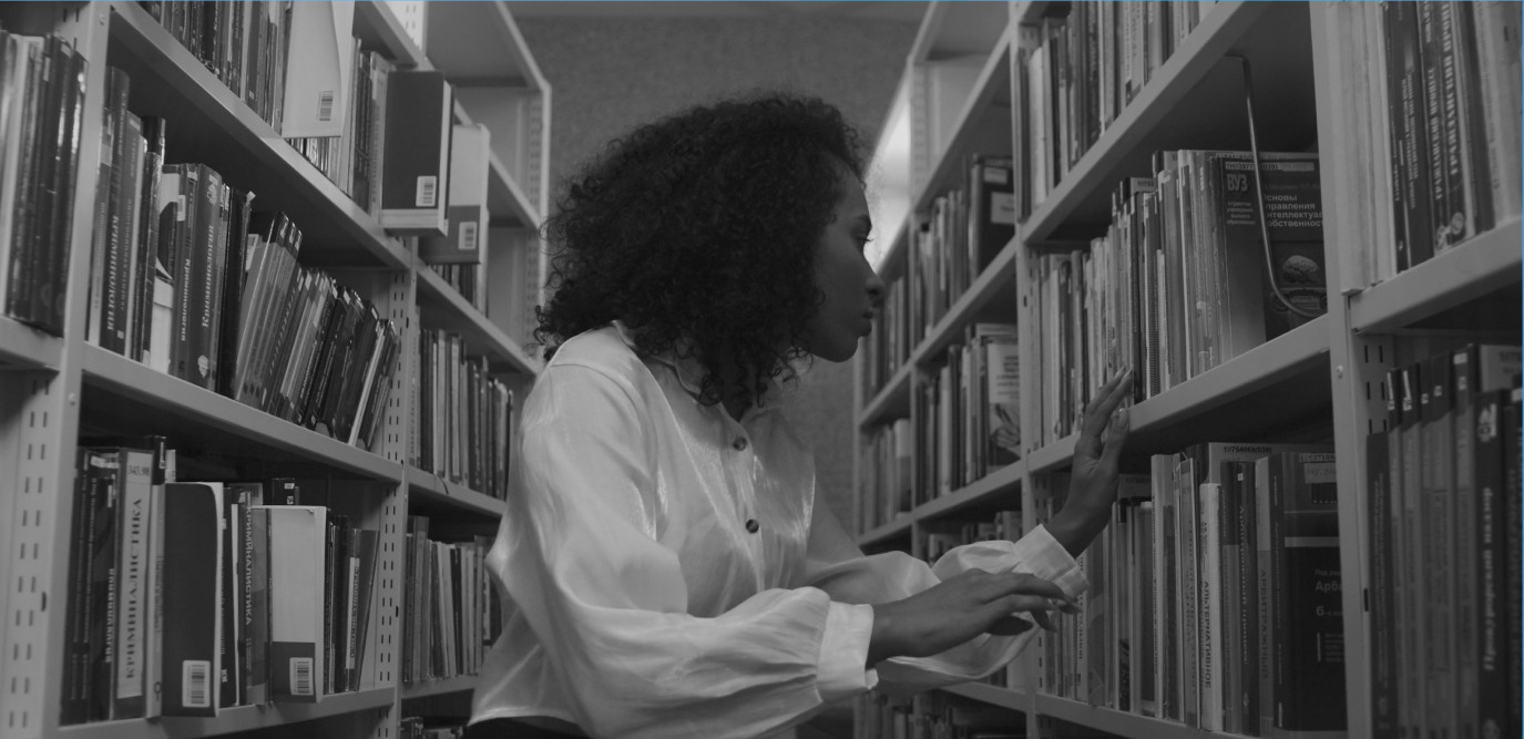 A researcher browsing books in a library